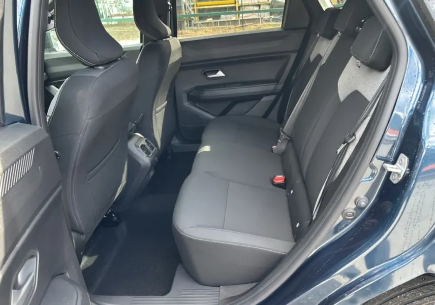 Vue côté droit de la banquette arrière noire du Dacia Bigster Hybrid 155 Journey Plus bleu indigo avec porte ouverte.