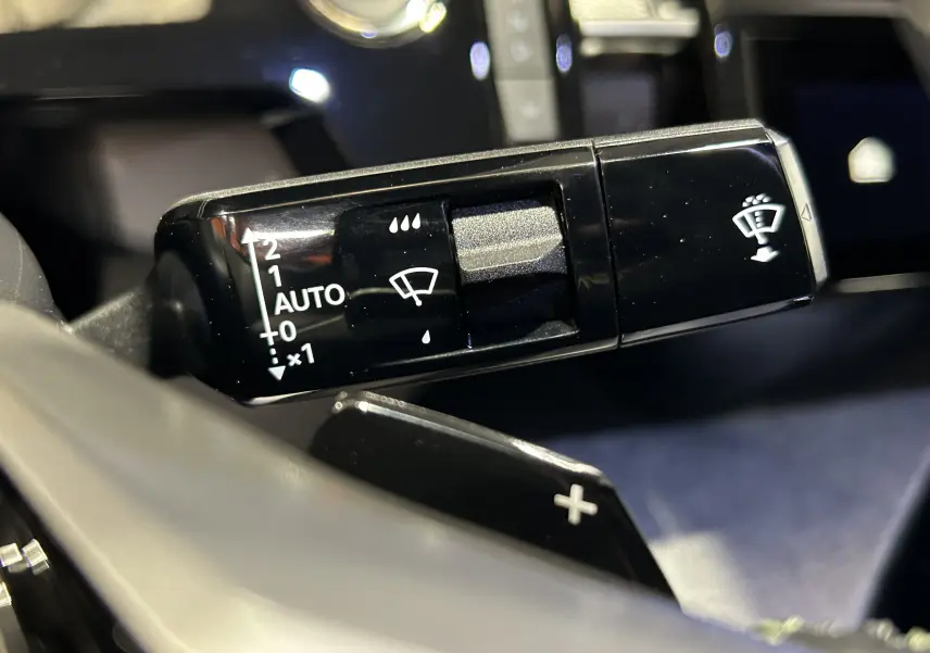 Gros plan sur la commande d’essuie-glace du Peugeot 3008 blanc Okenite, avec réglages automatiques visibles.