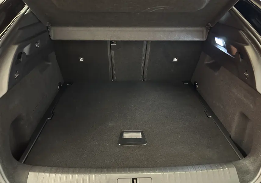 Coffre ouvert vu de l'arrière d'un Peugeot 3008 blanc Okenite, montrant un espace de chargement propre et bien éclairé.