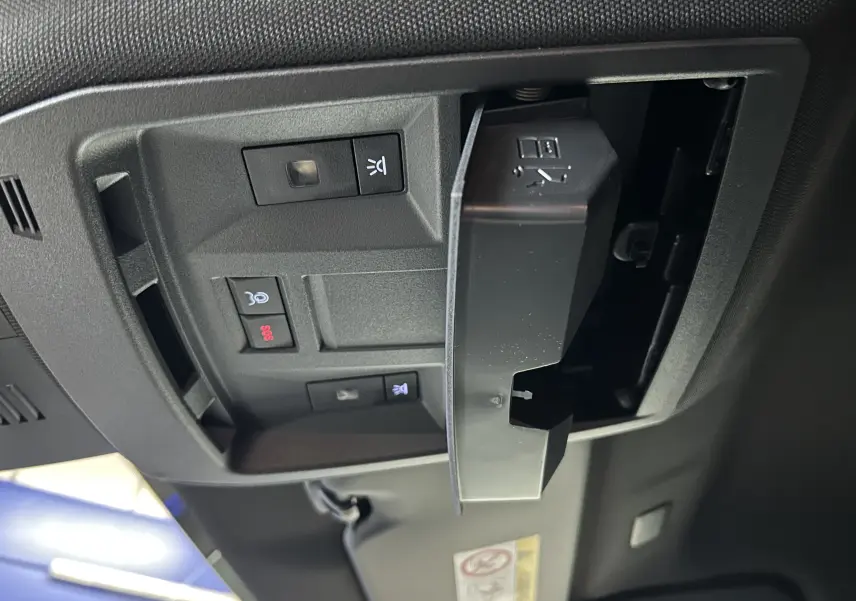 Vue en gros plan du panneau de commandes au plafond du Peugeot 3008 blanc, avec bouton SOS et éclairage intérieur.