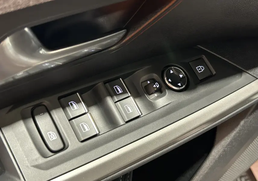 Gros plan sur les commandes des vitres et rétroviseurs côté conducteur de la Peugeot 3008 III Hybrid 145 en intérieur noir.
