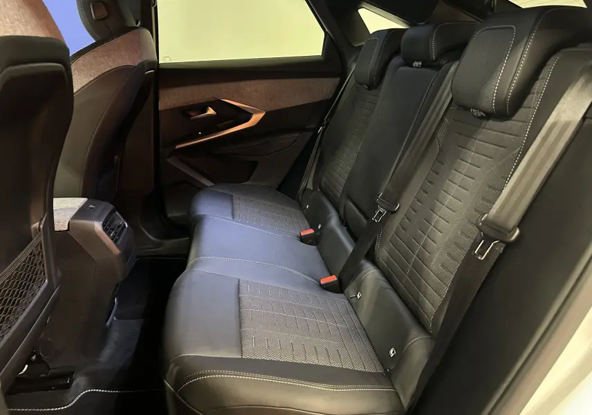 Vue intérieure côté droit des sièges arrière en cuir noir avec surpiqûres blanches et garniture tissu du Peugeot 3008 blanc Okenite.