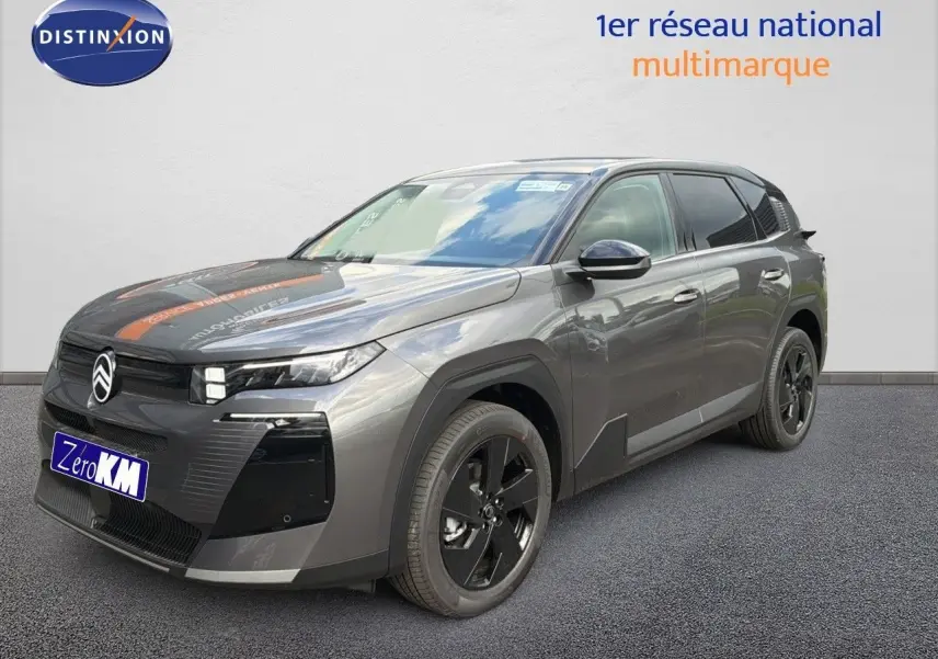 Vue 3/4 avant droit d'un Citroën C5 Aircross Hybrid gris platinium métal avec jantes noires et calandre distinctive.
