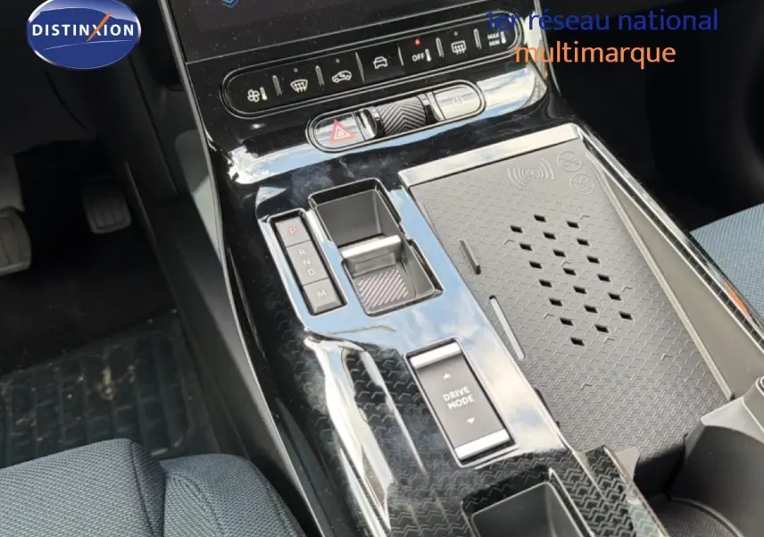 Vue plongeante sur la console centrale noire brillante du Citroën C5 Aircross Hybrid 2026 avec commandes de boîte auto et recharge sans fil.
