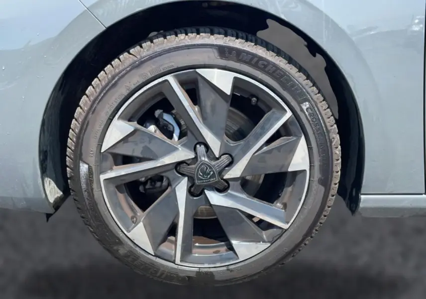 Gros plan sur la jante alu grise à design géométrique du côté gauche d’une Peugeot 308 gris 2025.