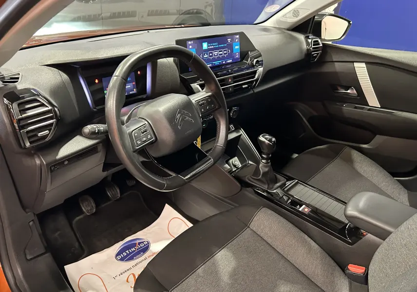 Intérieur de la Citroën C4 PureTech 100 Feel 2021, vue côté conducteur, tableau de bord et console centrale noirs.
