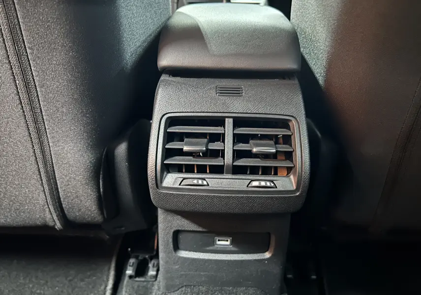 Détail des bouches d'aération arrière et port USB dans l'habitacle noir d'une Citroën C4 PureTech 100 Feel 2021.
