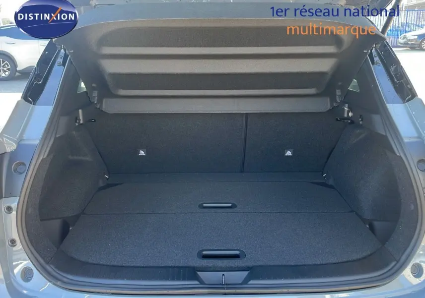 Coffre ouvert du Nissan Qashqai 2025 gris céramique métal avec toit noir, vue arrière montrant l'espace de chargement.