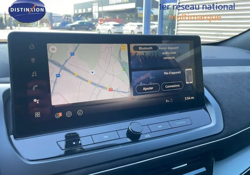 Vue intérieure du tableau de bord du Nissan Qashqai 2025 avec écran tactile affichant une carte et options Bluetooth.