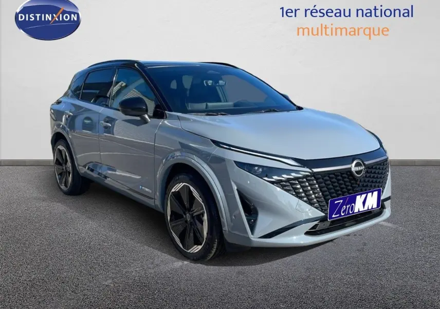 Nissan Qashqai 2025 gris céramique avec toit noir, vue 3/4 avant mettant en valeur sa calandre distinctive et ses jantes stylées.