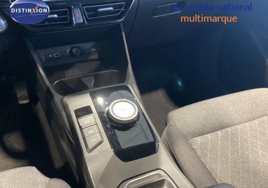 Vue rapprochée de la console centrale de la MG3 1.5L Hybrid+ 2024 avec molette de boîte auto et sièges tissu gris.