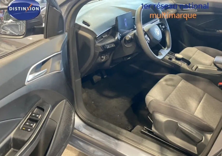Vue intérieure côté conducteur de la MG3 1.5L Hybrid+ 2024 en gris Hampstead, avec sièges tissu gris et tableau de bord moderne.