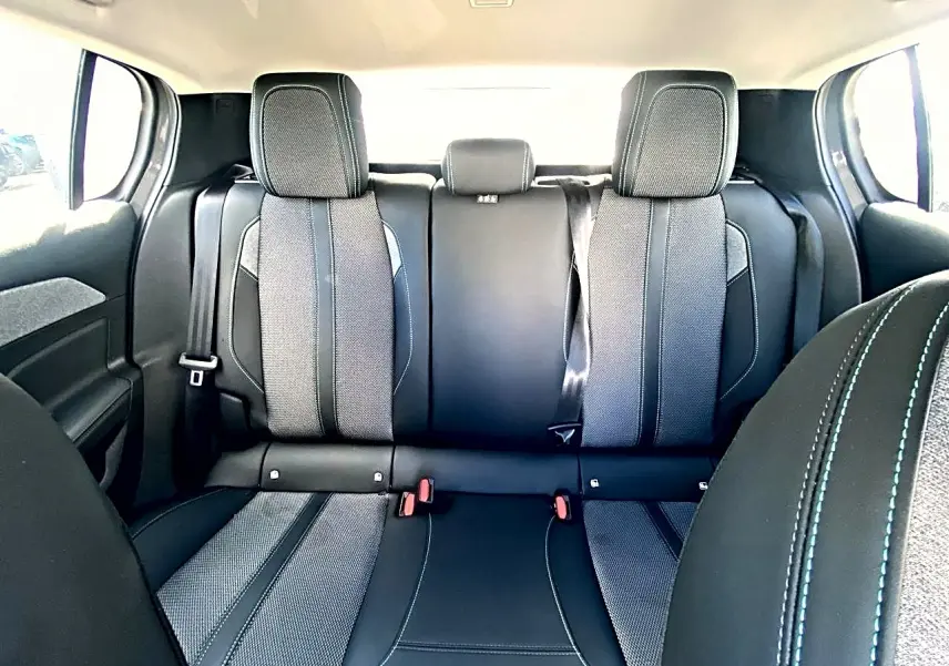 Vue arrière intérieure de la banquette arrière noire et grise de la Peugeot 308 2025 avec ceintures de sécurité visibles.