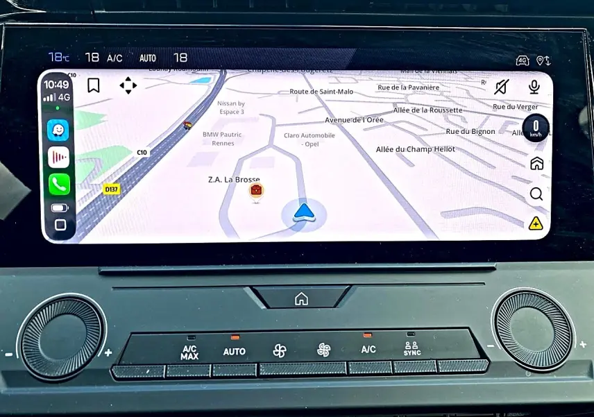 Gros plan sur l’écran tactile central et la console de climatisation de la Peugeot 308 gris 2025, affichant la navigation.