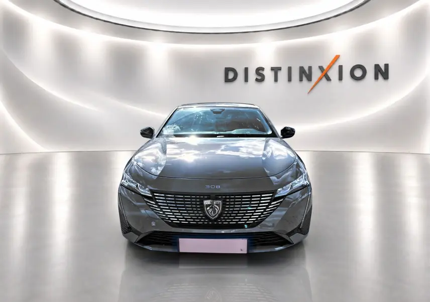 Vue frontale d'une Peugeot 308 gris métallisé 2025 avec calandre distinctive et logo lion au centre.