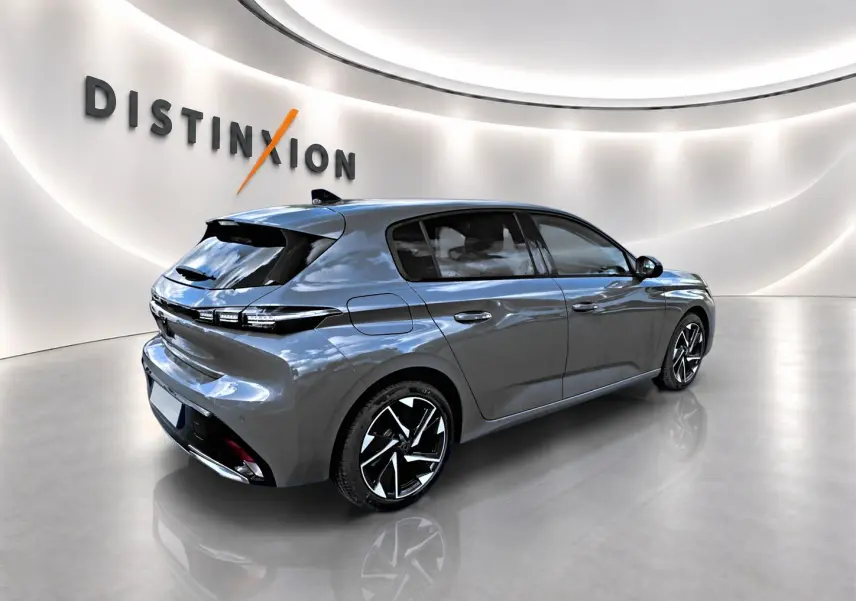 Peugeot 308 gris vue 3/4 arrière droit dans un showroom lumineux avec jantes alliage noires et détails LED.