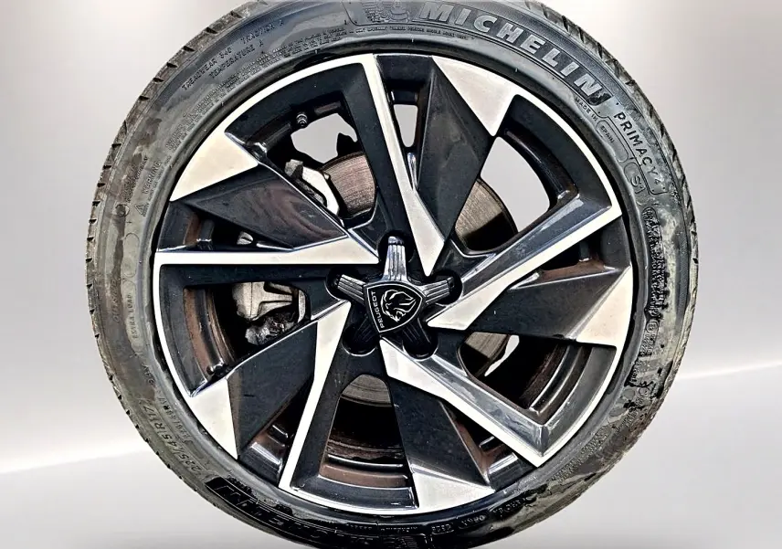 Gros plan sur la jante alu noire et argentée de la Peugeot 308 1.5 BlueHDi 130 Allure EAT8 avec pneu Michelin.