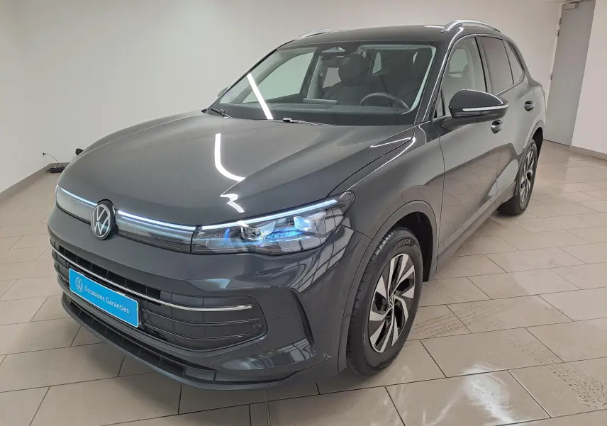 Volkswagen Tiguan 2024 gris Urano en vue 3/4 avant droit, avec phares LED et jantes alliage distinctives.
