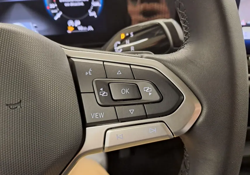 Gros plan sur les commandes multifonctions à gauche du volant en cuir du Volkswagen Tiguan 2024 gris Urano.