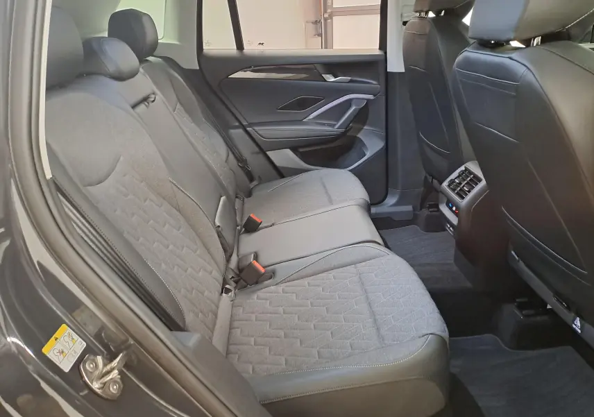 Vue intérieure côté gauche des sièges arrière gris du Volkswagen Tiguan 2024 avec finitions tissu et cuir.