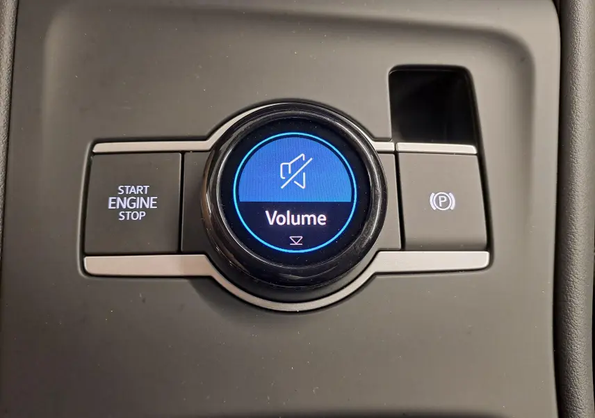 Gros plan sur la molette de volume et les boutons Start/Stop et frein à main électrique du Volkswagen Tiguan 2024.