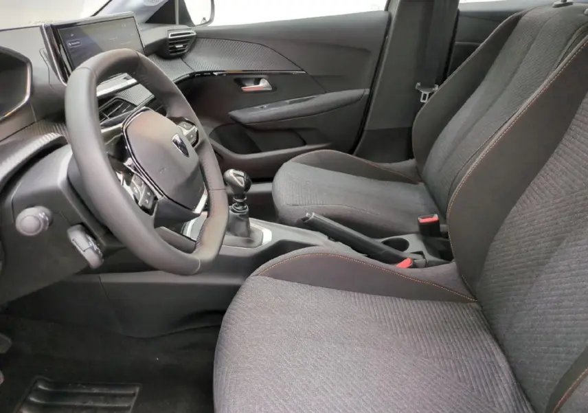 Intérieur avant droit de la Peugeot 208 gris clair, sièges tissu avec surpiqûres orange et volant compact cuir.