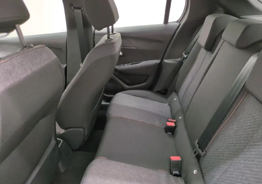 Vue intérieure arrière de la Peugeot 208 gris clair, sièges tissu avec surpiqûres orange Sunrise visibles.