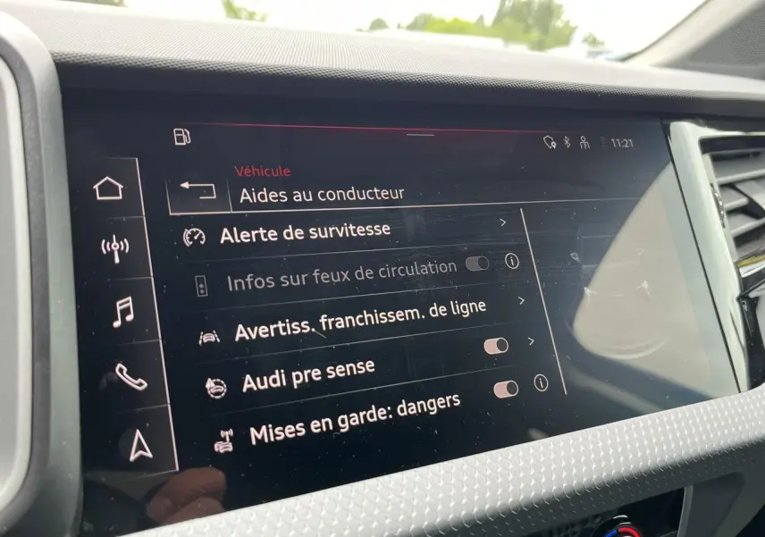 Écran tactile central de l'Audi A1 Allstreet 2022 affichant les aides à la conduite dans un intérieur moderne.