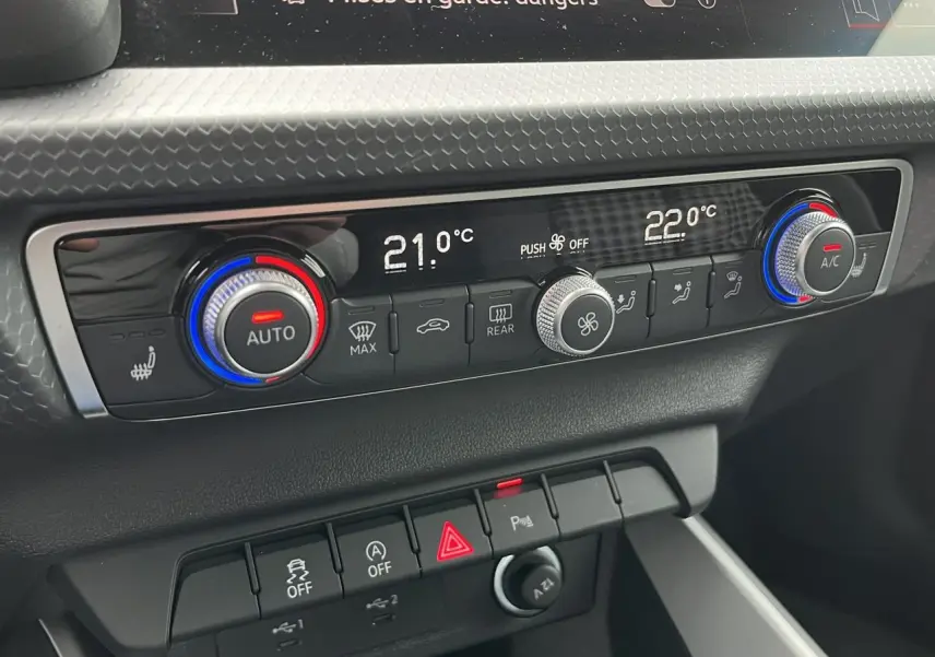 Gros plan sur la console centrale de l'Audi A1 Allstreet 2022, montrant la climatisation automatique et les commandes de sécurité.