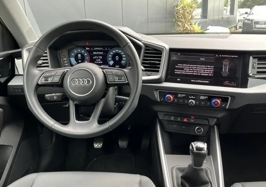 Vue intérieure centrée sur le volant cuir multifonctions et la console avec boîte manuelle de l'Audi A1 Allstreet.
