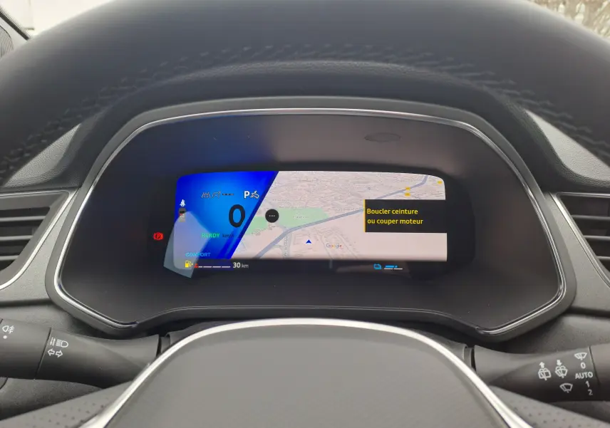 Vue rapprochée du tableau de bord numérique de la Renault Symbioz 2024 avec affichage de navigation et alertes sécurité.