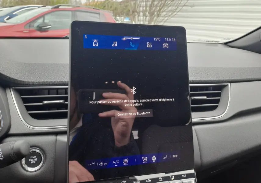 Écran tactile central allumé dans l'habitacle gris du Renault Symbioz 2024, avec bouton Start Engine visible à gauche