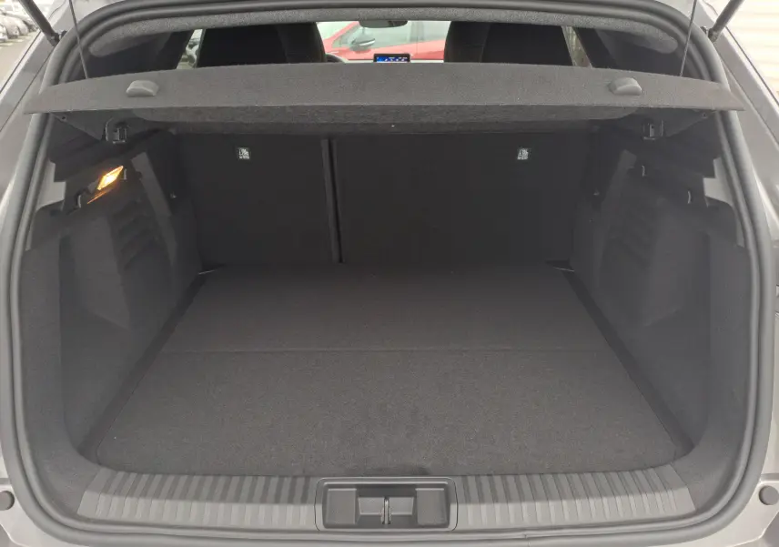 Coffre ouvert du Renault Symbioz gris Cassiope, montrant un espace de chargement propre et bien éclairé.