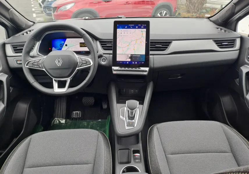 Intérieur Renault SYMBIOZ 2024, vue frontale du tableau de bord avec écran tactile vertical et sièges tissu gris.