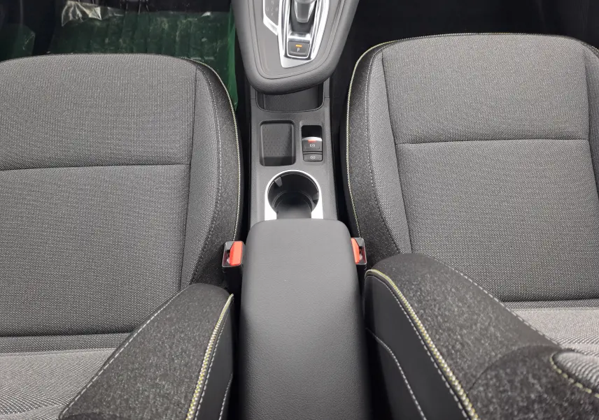 Vue plongeante sur la console centrale et sièges avant en tissu gris foncé de la Renault Symbioz 2024.