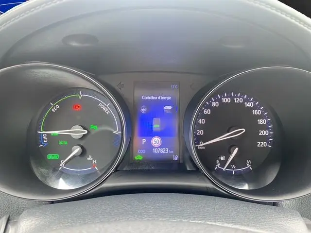 Tableau de bord du Toyota C-HR Hybride blanc toit noir, affichant les compteurs et l'écran central d'énergie.