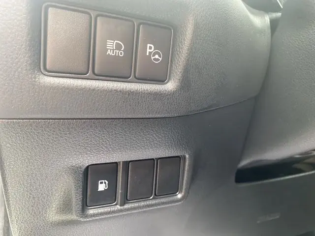 Détail intérieur montrant les boutons de commande noirs sur le tableau de bord du Toyota C-HR Hybride blanc toit noir.