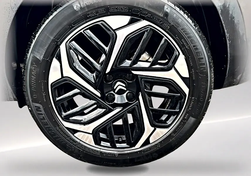 Gros plan sur la jante alu noire et argentée de la Citroën C4 gris 2024, mettant en valeur son design moderne.