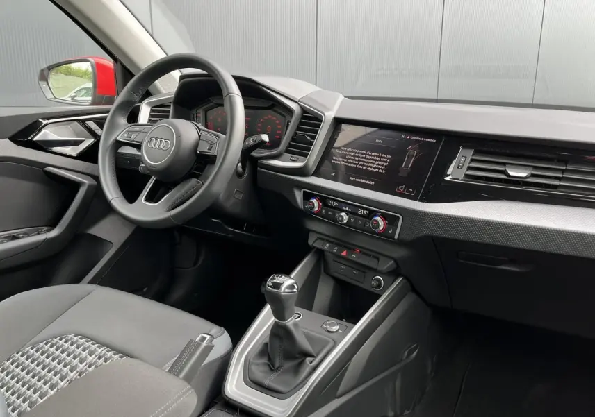 Intérieur Audi A1 Sportback 2022 vu côté conducteur, volant cuir 3 branches et levier de vitesse manuel visible.
