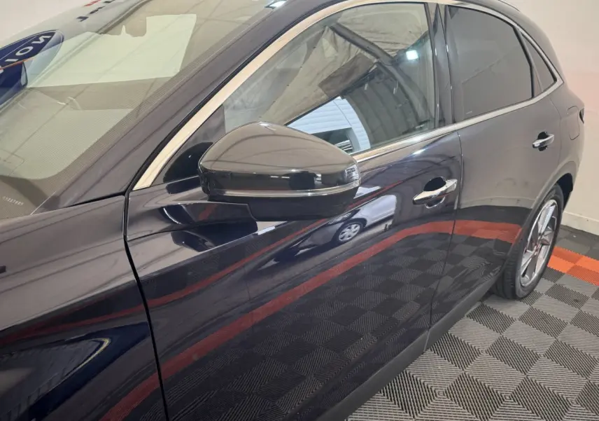 Vue latérale droite du DS7 Crossback E-TENSE bleu, mettant en valeur la portière et le rétroviseur noir brillant.