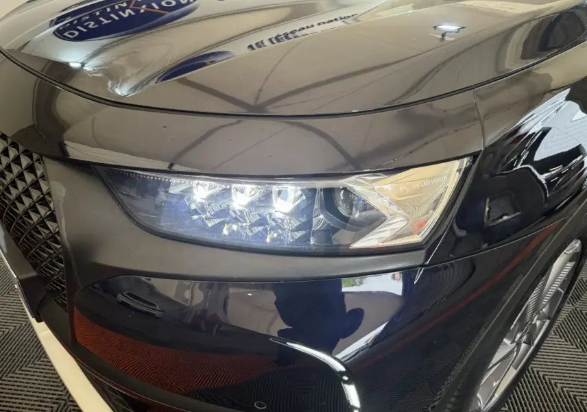 Gros plan sur le phare avant droit bleu du DS7 Crossback E-TENSE 4x4 avec signature lumineuse LED distinctive.
