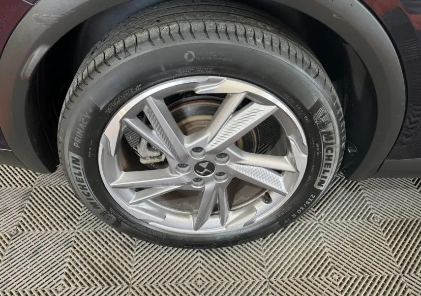 Gros plan sur la roue avant droite du DS7 Crossback E-TENSE bleu, avec jante alliage et pneu Michelin Primacy 4.