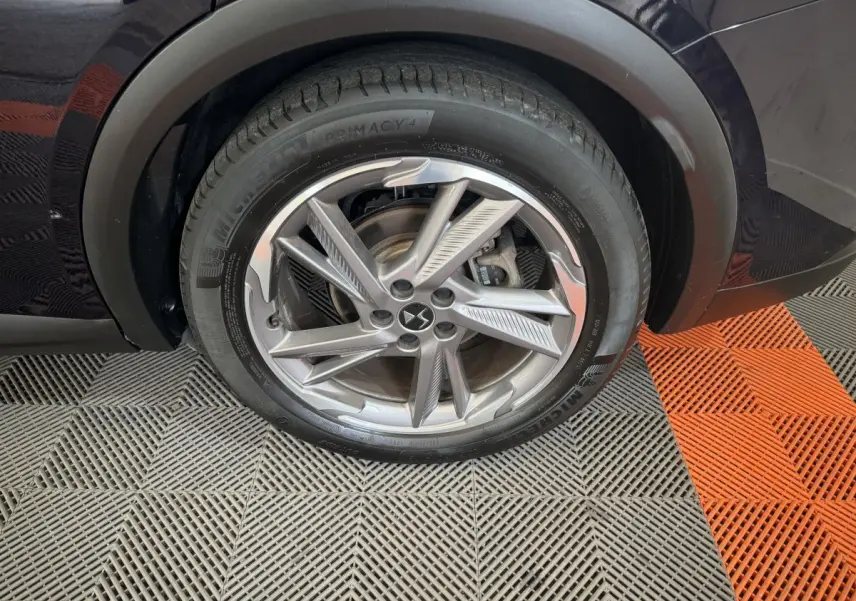 Gros plan sur la roue avant gauche bleu foncé du DS7 Crossback E-TENSE avec jante alliage au design moderne.