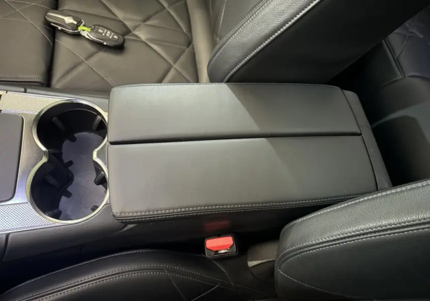 Gros plan sur la console centrale en cuir noir du DS7 Crossback E-TENSE 4x4 avec clé posée sur le siège côté droit.