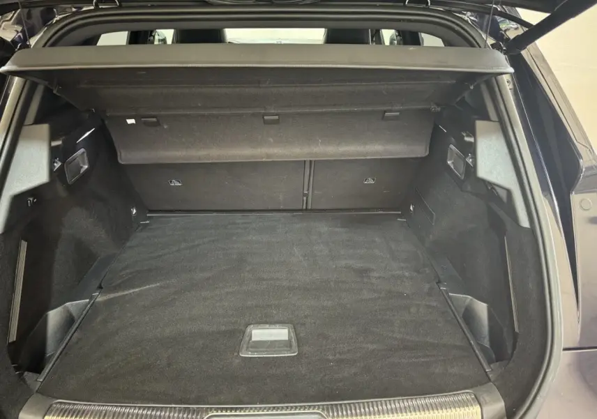 Coffre ouvert du DS7 Crossback E-TENSE bleu, montrant l'espace de chargement et la tablette arrière noire.