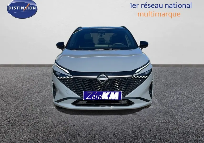 Vue frontale d'un Nissan Qashqai 2025 gris céramique avec toit noir, calandre noire et phares LED fins.