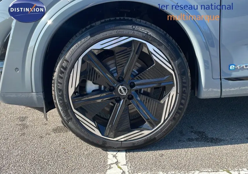 Gros plan sur la roue avant gauche du Nissan Qashqai gris céramique avec jante noire et grise au design moderne.