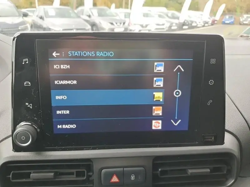 Écran tactile du tableau de bord du Peugeot Partner blanc 2019 affichant les stations radio en extérieur.