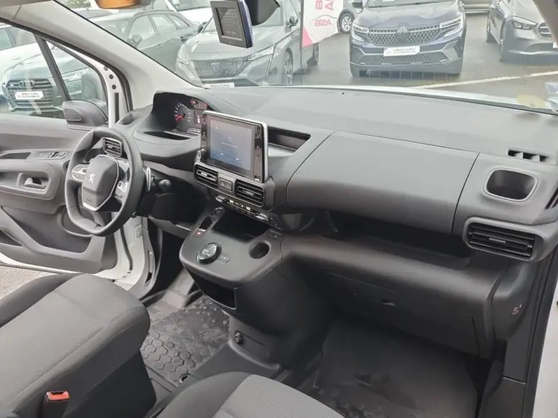 Intérieur avant du Peugeot Partner blanc 2019, vue côté conducteur montrant tableau de bord moderne avec écran tactile central.