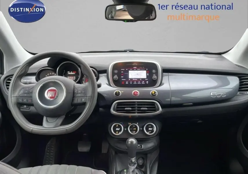 Intérieur de Fiat 500X gris foncé, vue frontale du tableau de bord avec volant multifonction et écran tactile central.